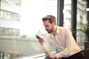 Modelo de Petição: Ação de Obrigação de Fazer com Indenização por Danos Morais contra Banco por Ligações Robotizadas 1 | Juristas Photo of Man in White Dress Shirt Holding Phone Near Window