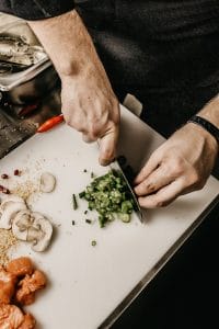 Modelo de petição de ação de reparação a título de danos morais e materiais por ter comido alimento estragado em Restaurante 1 | Juristas person slicing vegetable