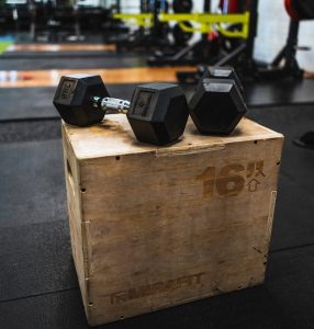 black and gray dumbbells on brown wooden crate