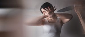 woman in white tank top covering face